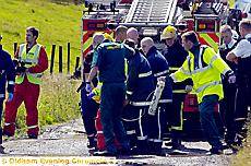 Firefighters and paramedics carry the pilot to the air ambulance 