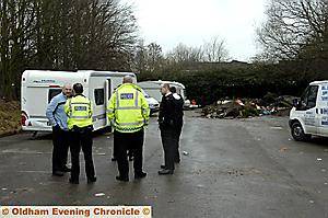 Police stand by as the travellers are moved off. 