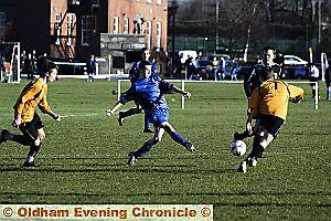 SIDE-FOOT PASS: Chase Harrison, of Oldham Schools under-15s, slides the ball through the Salford defence. 