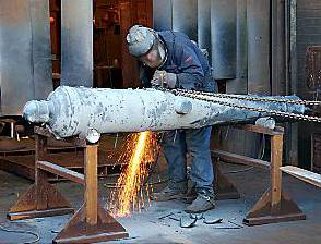 A worker at Premier Castings grinds the newly-cast cannon 
