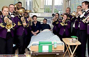 IN tune . . . members of Delph Band and Phil’s wife Jacqui and daughter Rebecca at the conductor's bedside 