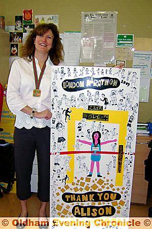 MARATHON woman Alison Vesey shows off her medal and the poster 