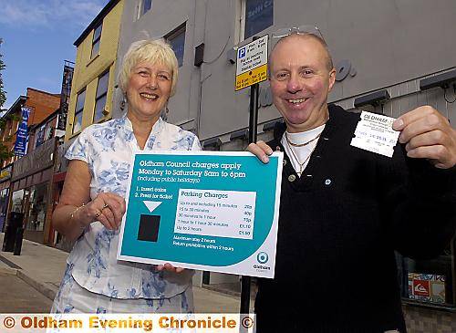 PARKING prices plummet . . . Councillor Lynne Thompson and Zutti owner Paul Hughes with the new sign showing reduced on-street parking prices in Oldham town centre 