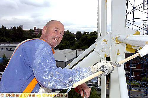 Craig Mills (from Temple Summerville) puts the finishing touches to the repainting job at Boundary Park. 