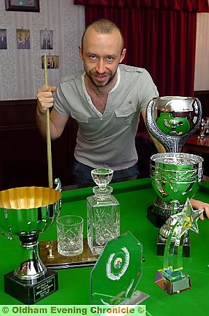 BAIZE OF GLORY . . . Michael shows off the many trophies in his Moorside snooker room. 