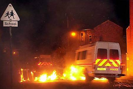 police vans drive through flames in the early hours as gangs of youths hurled petrol bombs at officers and erected burning barricades on the riots’ second night 
