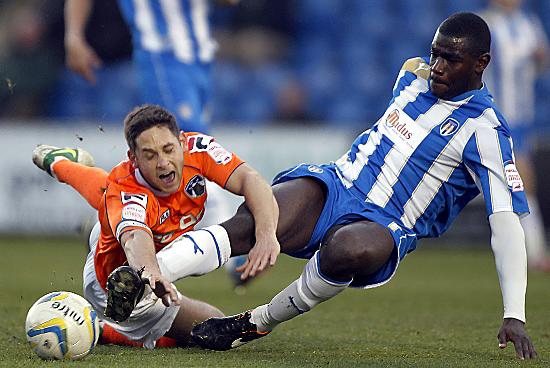 Athletic skipper Dean Furman feels the full force of a challenge by Colchester centre-back Magnus Okuonghae. 