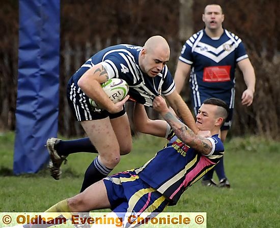 Hollinwood's Alistair Williams tries to force his way past Whinmoor opponents.