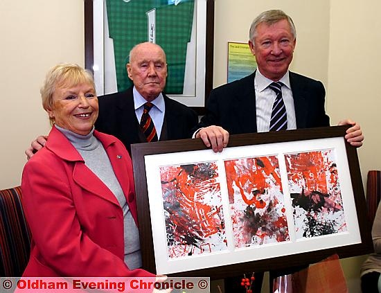 GIFT for Sir Alex: Jack Crompton and his wife Sheila Crompton holding a painting done by the pupils for the United boss 