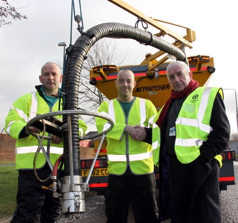 Oldham Council road maintenance workers Peter Smith and Wayne McManus show Councillor Dave Hibbert the council’s jet patcher machine 
