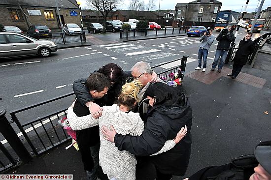 HEARTACHE . . . the family after laying flowers at the scene 