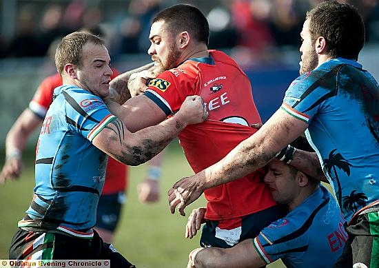 Roughyeds’ Sam Gee holds on in the face of Hornets pressure. 