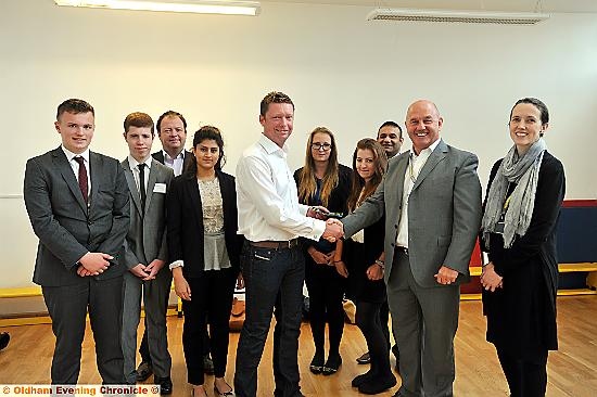 John Roberts is welcomed to Mahdlo by chairman Terry Flanagan (second right), watched by Ian Taylor, from Team Spirit (third from left), Councillor Shoab Akhtar, deputy leader of Oldham Council (third from right), Mahdlo chief executive Helen Taylor (right) and students from Blue Coat School 
