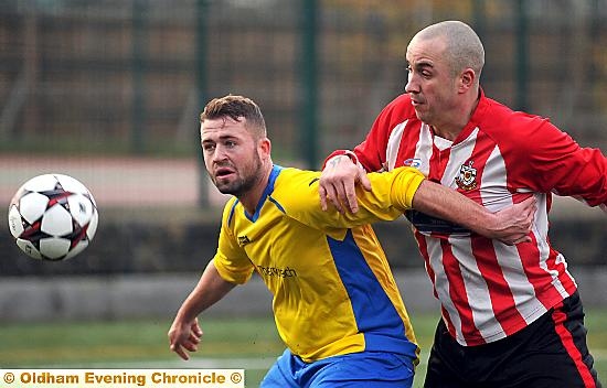 EYE ON THE BALL: Royton’s Carl Caffrey (in yellow) holds of a Sacred Heart opponent. PICTURE: TIM BRADLEY