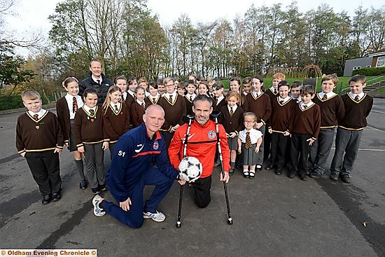GUNNING FOR GLORY: Great Britain amputee coach Pete Wild (front, left) and player Dave Tweed are pictured with Year Six on a visit to St Joseph’s RC Primary School. 