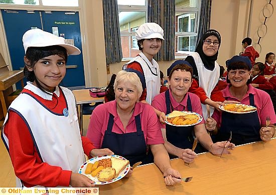 YOUNG cooks serve dinner to the cooks at the Roundthorn Primary Academy. From left, Aizah Ali, Audrey Heaton, Safa Kanwal, Ann Lees, Aisha Shahazady, Anne Wrigley