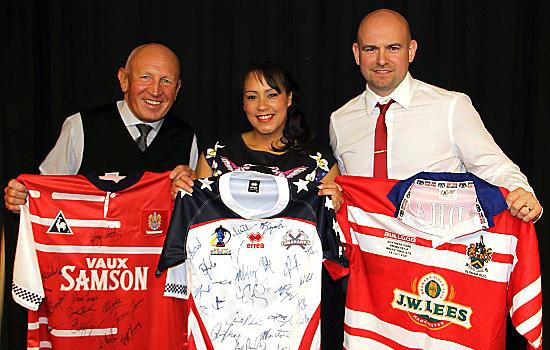 GETTING SHIRTY: Neil Roden (right) shows off auction items alongside his wife, Tanya, and MC Jack Dearden. Picture: Dave Murgatroyd
