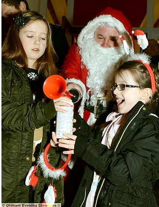 THE sound of Christmas: Abigail Booth (left) and Millie Wardyn are joined by Santa