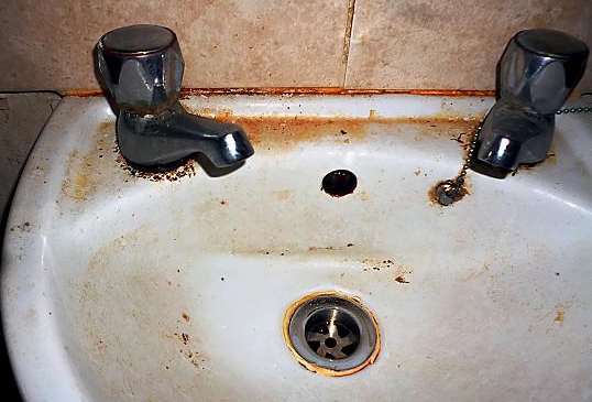 A filthy sink and tiles in the takeaway. 
