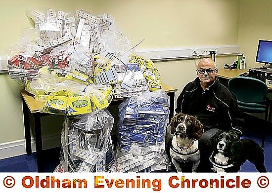 Hounding out illegal activity: Bradley and Buster with handler Hugh Williams and the seized haul of counterfeit or illegal tobacco