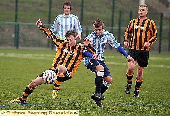 Heyside’s Reece Hursthouse (Blue) challenges a Kirkheaton Rovers opponent with teammate Ryan Barnes looking on.