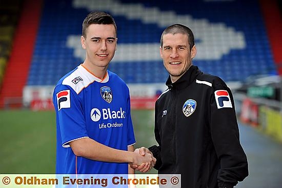 WELCOME ABOARD . . . striker Rhys Turner shakes hands with Athletic first-team coach Paul Murray after signing today 
