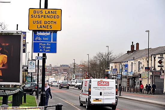 conflicting blue and yellow signs on Huddersfield Road 
