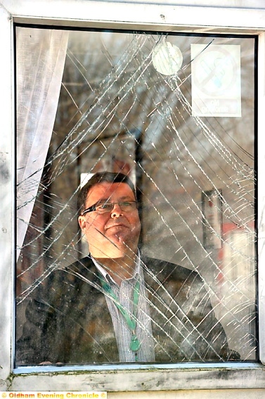 COUNTING the cost: Oldham RL chairman Chris Hamilton looks through a broken window after the latest attack.