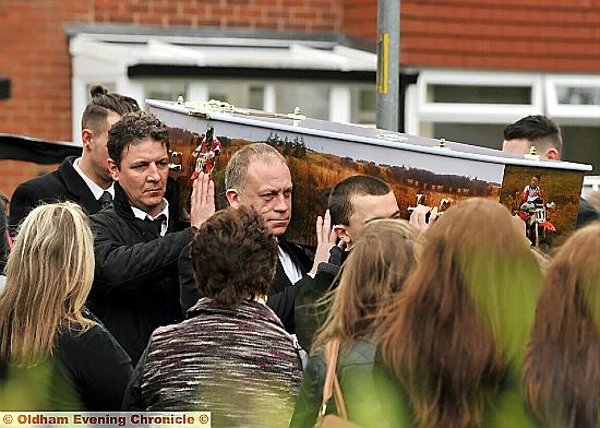Friends and family members carry Leon’s coffin as mourners look on 
