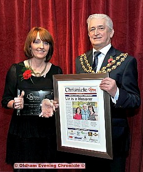 Proud: last year’s Special Achievement Award winner Liz Whitworth is presented with her trophy and framed front page by Oldham Mayor, Councillor John Hudson 

