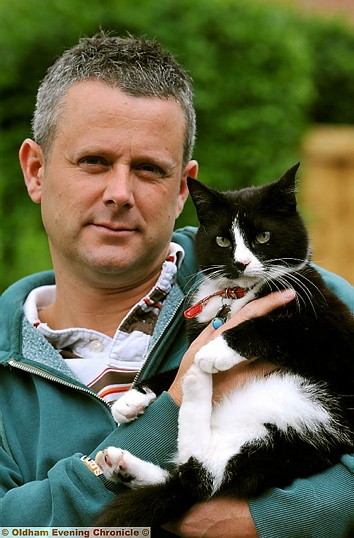 WARNING to pet owners . . . Jon Baylis and his cat George, who was caught in a snare.