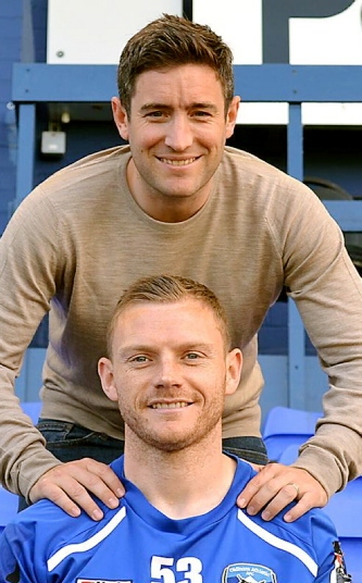 RIGHT BEHIND YOU: boss Lee Johnson welcomes defender Brian Wilson to Boundary Park.