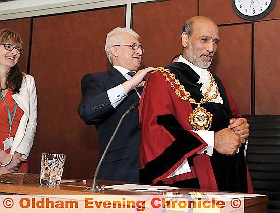 Outgoing mayor Councillor John Hudson hands over chain of office to Councillor Fida Hussain. 