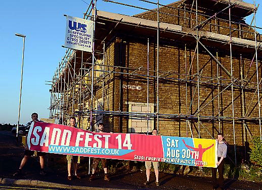 Members of Saddleworth Round Table prepare to raise the banner at the former Star Inn to advertise Sadd Fest 14.