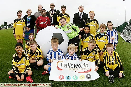READY to play . . . Players from Medway u12s (yellow strip) and Stalybridge u7s (blue and white strip) with (back from the left) Ann Hanaghan, chair of governors at Failsworth School, John Meagher, head teacher at Failsworth School, the Mayor of Oldham, Councillor Fida Hussain ,and John Taylor, MYMSL chairman. 