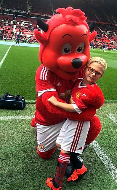 MATCH mascot . . . Riley Parrish with Fred the Red before the game