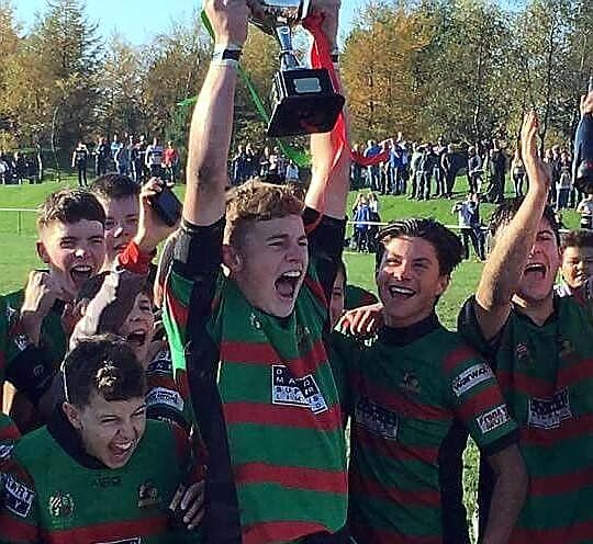 WHAT A CELEBRATION . . . Waterhead under-14s captain Callum Cameron raises the Oldham Youth and Juniors trophy.