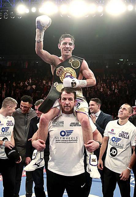 Anthony Crolla poses on his trainers shoulders in celebration.