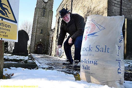 Brian Devenport Deputy Church Warden at The Church of St. Anne, Lydgate spreads salt on the church path. 