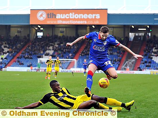 OVER YOU GO . . . Mark Yeates hurdles a Burton defender as he tries to get Athletic moving forward. 