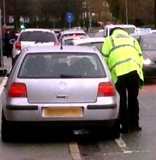 POLICE speak to a motorist illegally parked