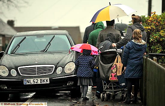 A tight squeeze for children, parents and buggies as they attempt to get past cars on the pavement.
