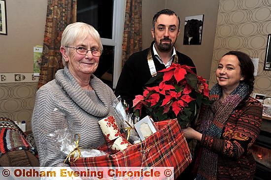 CHRISTMAS gifts . . . Marlene Horton receives her hamper from Saddleworth Round Table chairman Matthew Skyes and neighbour Jackie Warburton
