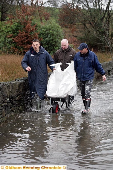 RELIEF effort . . . rugby star Kevin Sinfield helps out in Coverhill Road, Grotton