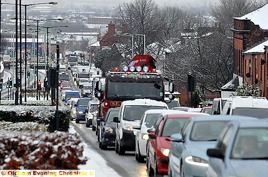 SNOW going: traffic tails back along Manchester Road. Pictures by TIM BRADLEY and ANTHONY MILLER
