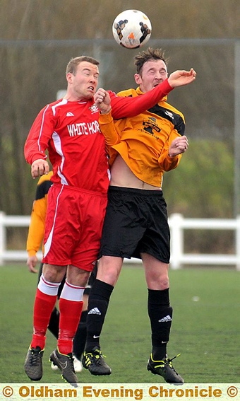 EYES WIDE SHUT . . . Adam Kay (left), of Old Ashtonians, and AFC Oldham’s Neil Hardman go head to head in an aerial duel. PICTURE: TIM BRADLEY