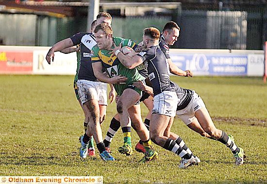 BREAKING THROUGH: Oldham’s Josh Crowley tries to squeeze between Swinton defenders. PICTURE: TIM BRADLEY