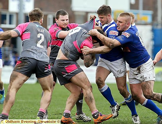 WRAPPED UP: Oldham’s Sam Gee (centre) is left with nowhere to go, but ultimate victory belonged to the Roughyeds. 