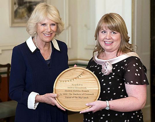 Community champion . . . Andrea is presented with a commemorative plate by Camilla.