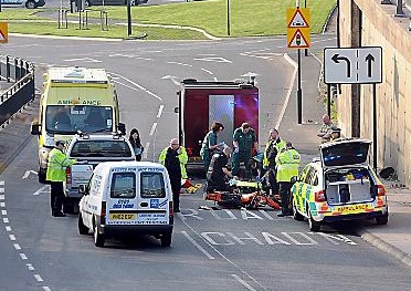 Emergency service personnel help the injured motorcyclist